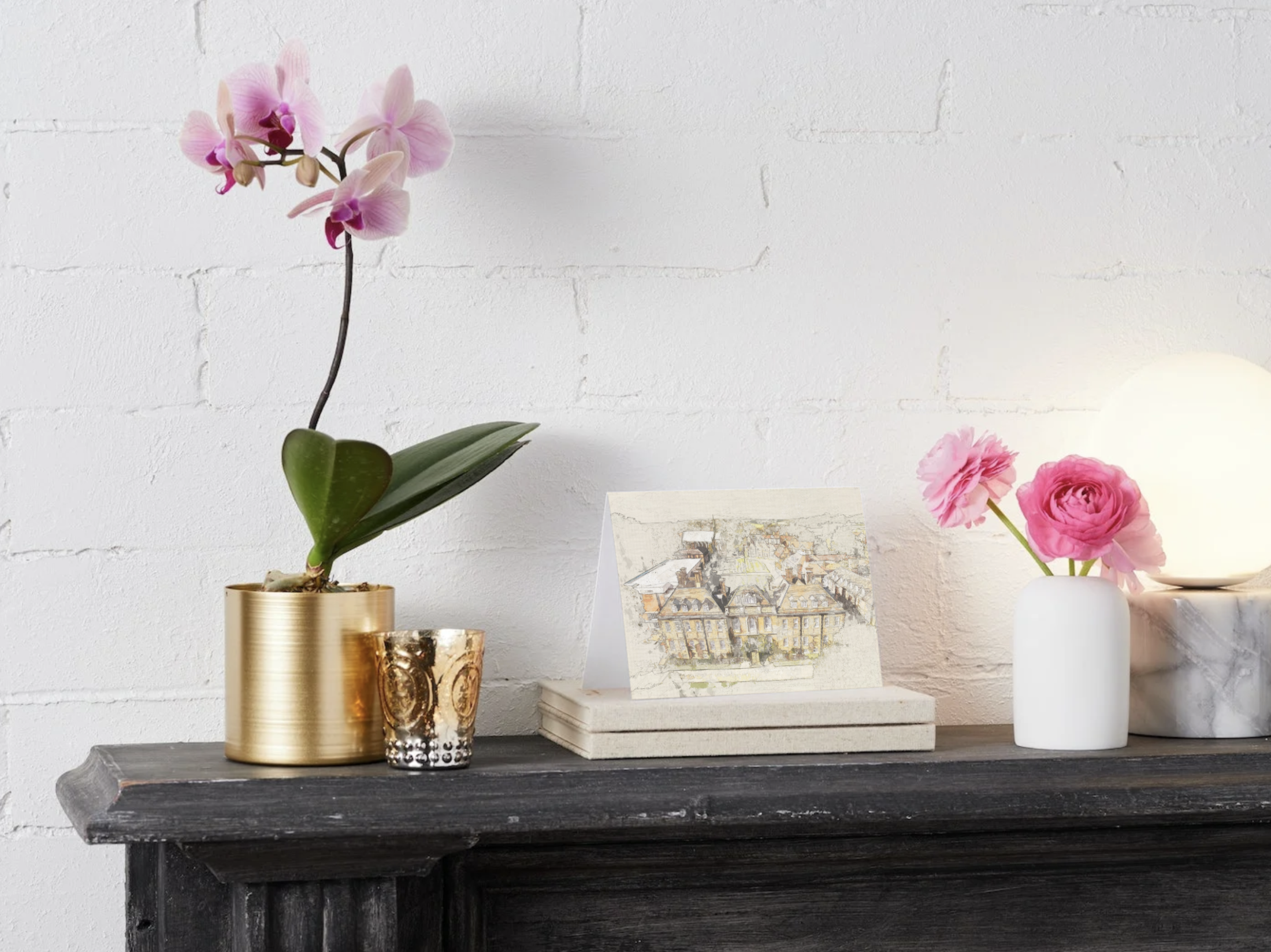 A Marlborough Photo greetings card displayed on a mantelpiece between flowers and plants